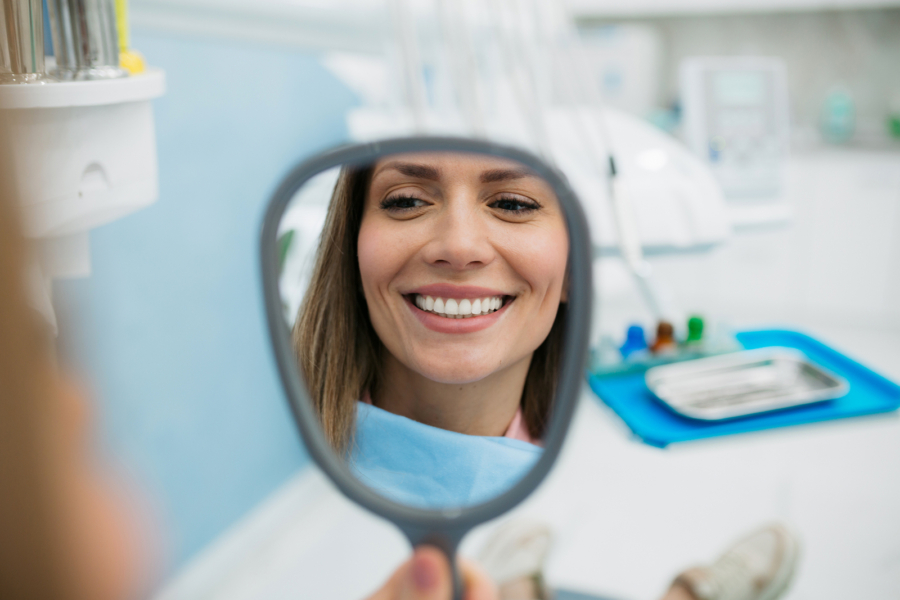 woman looking herself in the hand held mirror image