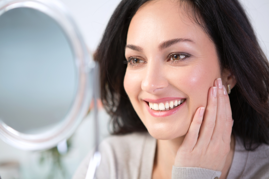 Woman smiling and looking at mirror. image
