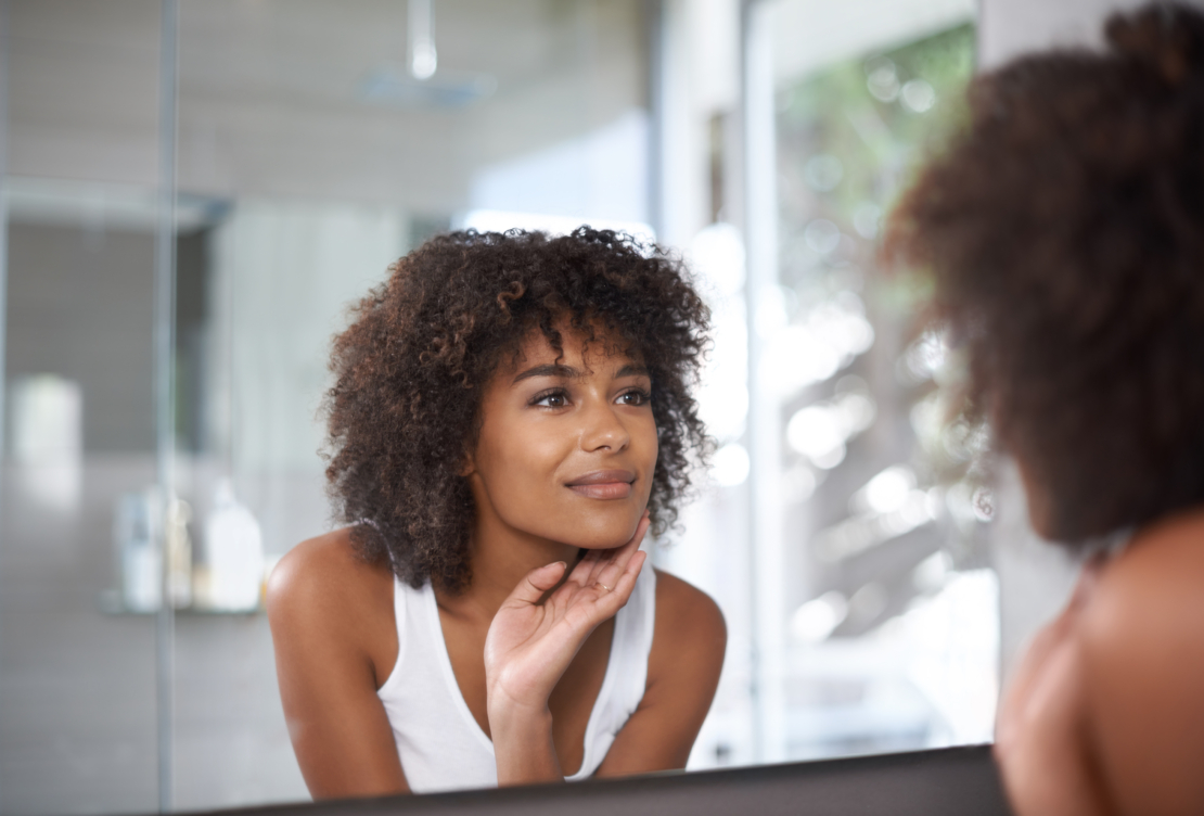 woman looking at herself in the bathroom image